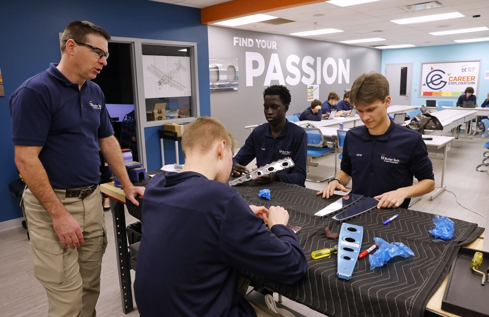 Aviation instructor Rich Packer helps seniors Jacob Cole, left, Mouhammed Thiam, middle, and Cody Meiser work on constructing a section of an airplane during their aviation class at Butler Tech Wednesday, March 26, 2025 in Farifield Township. Students are building an airplane with parts and build plans supplied by Tango Flight. NICK GRAHAM/STAFF