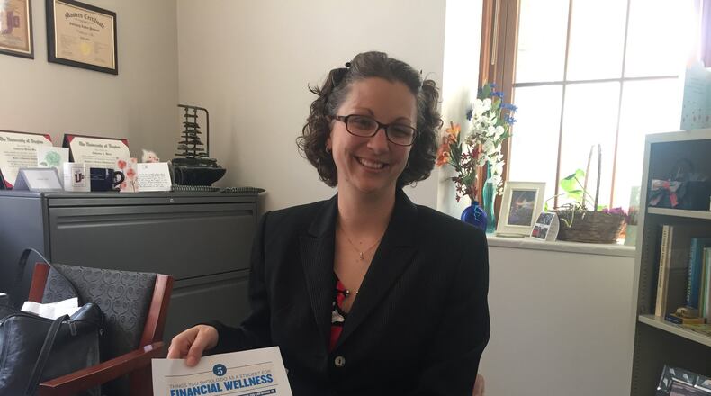 Catherine Mix, University of Dayton assistant vice president of financial aid, holds a form her office provides to students in one-on-one financial counseling sessions. UD and Wittenberg University are two of only a few universities in the state that offer individualized counseling to all students.