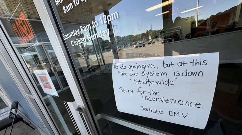 A sign posted to the door at the Ohio BMV site in Springfield Friday morning, July 19, 2024, said the office is closed because its system is down statewide. BILL LACKEY/STAFF