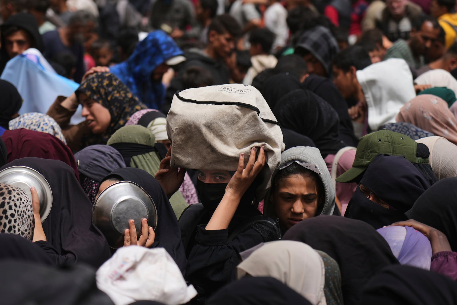 Palestinians wait for donated food at a distribution center in Nuseirat, central Gaza Strip, Wednesday, April 30, 2025. (AP Photo/Abdel Kareem Hana)