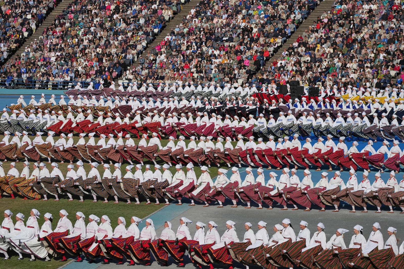 Participants perform during the Estonian Song and Dance Celebration "Iseoma" at the Kalev Stadium in Tallinn, Estonia, Friday, July 4, 2025. (AP Photo/Sergei Grits)