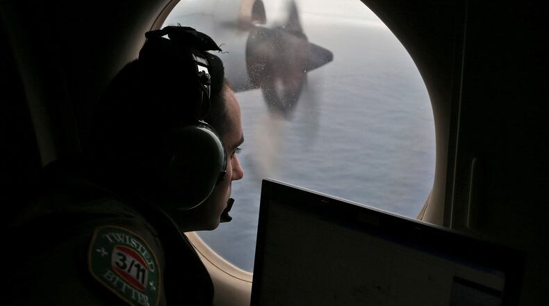 FILE - Flight officer Rayan Gharazeddine scans the water in the southern Indian Ocean off Australia from a Royal Australian Air Force AP-3C Orion during a search for the missing Malaysia Airlines Flight MH370 on March 22, 2014. (AP Photo/Rob Griffith, File)wld