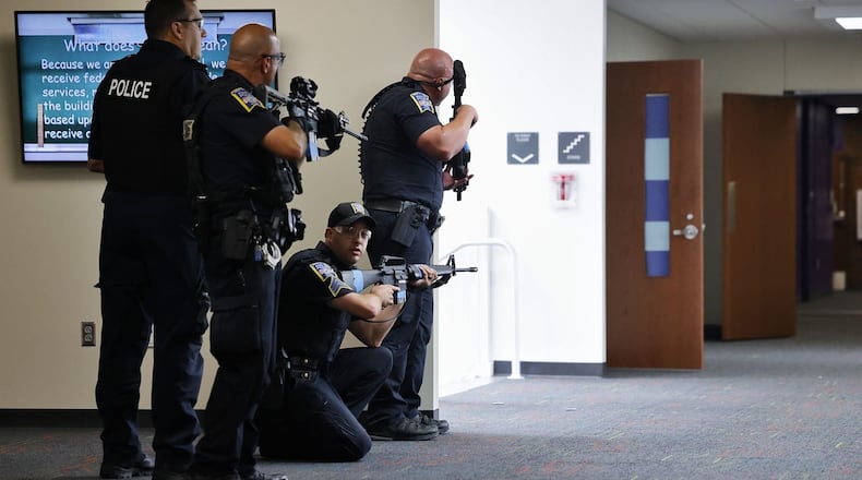Earlier this week Ohio Governor Mike DeWine announced more than 1,000 K-12 individual school buildings and districts will be sharing parts of a $47 million in grants to enhance school security. 	Two Butler County school districts – Lakota and Fairfield – are among the top five school systems in the state to receive the largest amounts of money. Pictured are Middletown Police officers recently training for an active school shooter scenario. (Photo By Nick Graham\Journal-News)