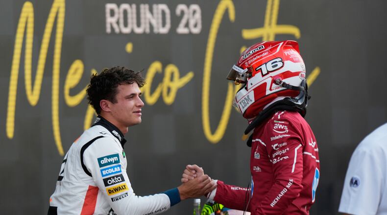 McLaren driver Lando Norris of Britain, left, the pole position winner, is congratulated by Ferrari driver Charles Leclerc of Monaco, who qualified second, during the qualifying session for Formula One Mexico Grand Prix auto race at the Hermanos Rodriguez race track in Mexico City, Saturday, Oct. 25, 2025. (AP Photo/Fernando Llano)