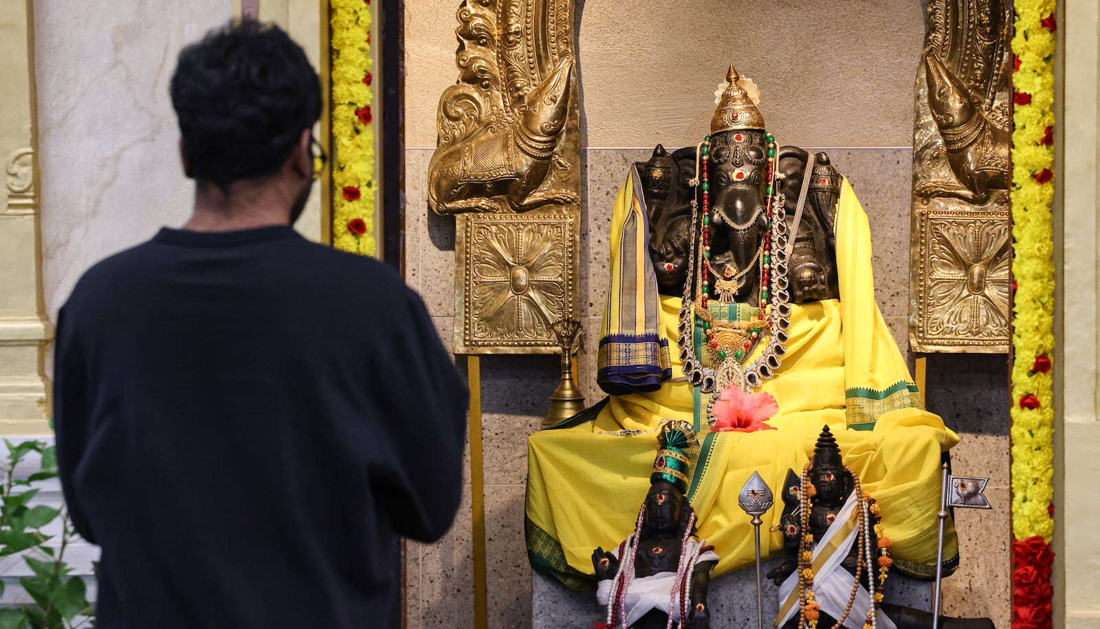 A worshiper prays in front of a murti during a Diwali service at Hindu Temple of Dayton on Tuesday, Oct. 20 in Beavercreek. BRYANT BILLING/STAFF