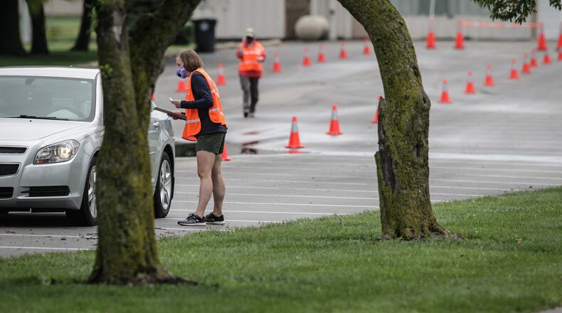 Members of Montgomery County Public Health and the Ohio National Guard help with pop-up testing Tuesday at Kettering Fields, 444 North Bend Blvd. Results from the latest coronavirus pop-up testing site are expected in a more timely manner and results are accessible online to patients, following a switch to a new laboratory. JIM NOELKER/STAFF
