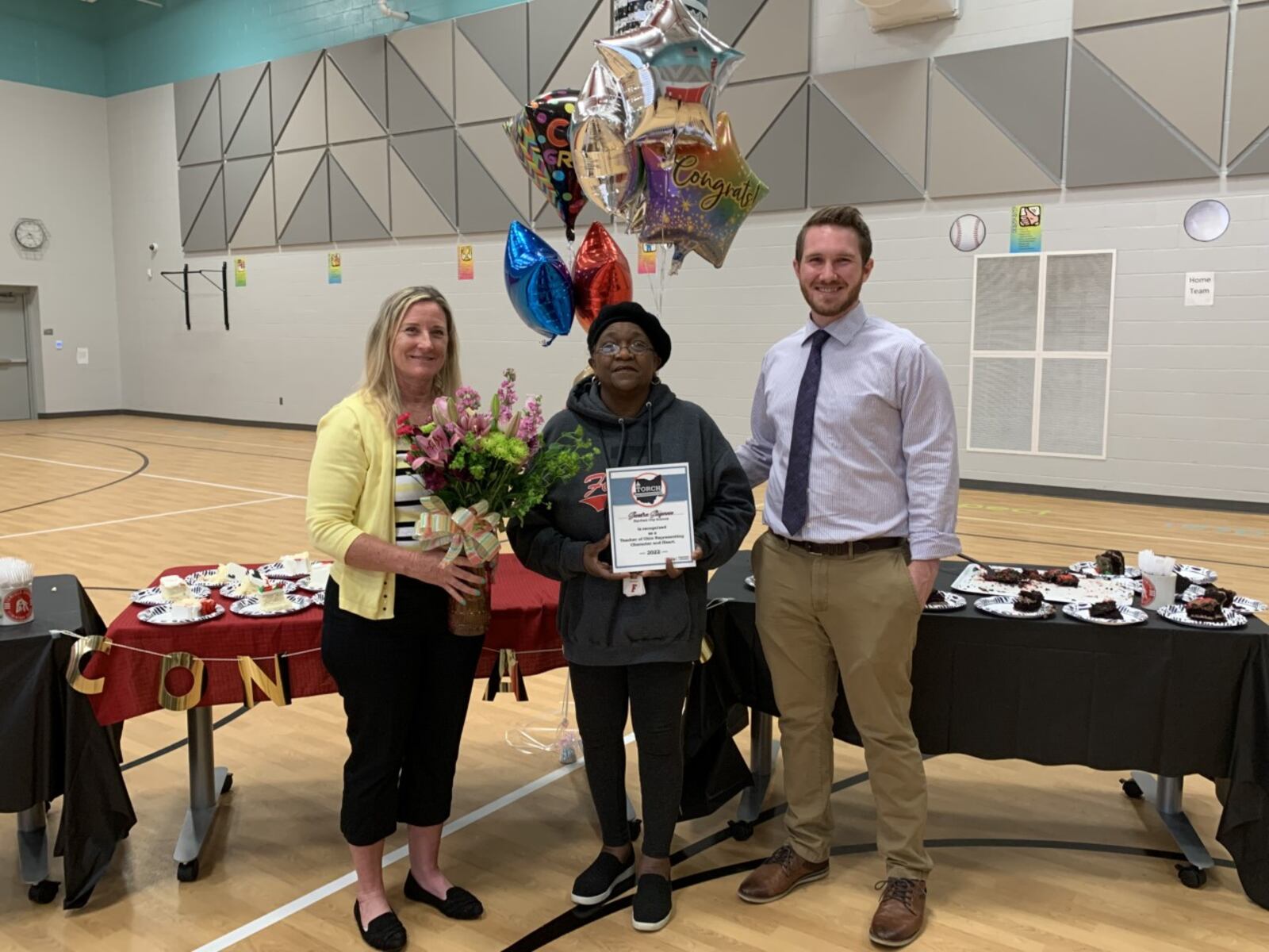 Veteran Fairfield Schools teacher Sandi Stegman, center, is flanked by Ohio Department of Education committee officials during her recent, surprise ceremony at Central Elementary revealing she has won a top Ohio schools award. Stegman, 70, is a 20-year veteran teacher and a former IBM computer engineer who found her true calling in life later as a teacher. (Contributed Photo\Journal-News)