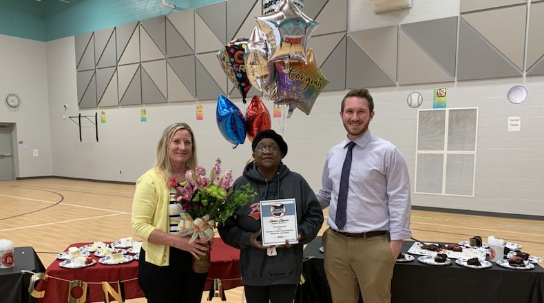 Veteran Fairfield Schools teacher Sandi Stegman, center, is flanked by Ohio Department of Education committee officials during her recent, surprise ceremony at Central Elementary revealing she has won a top Ohio schools award. Stegman, 70, is a 20-year veteran teacher and a former IBM computer engineer who found her true calling in life later as a teacher. (Contributed Photo\Journal-News)