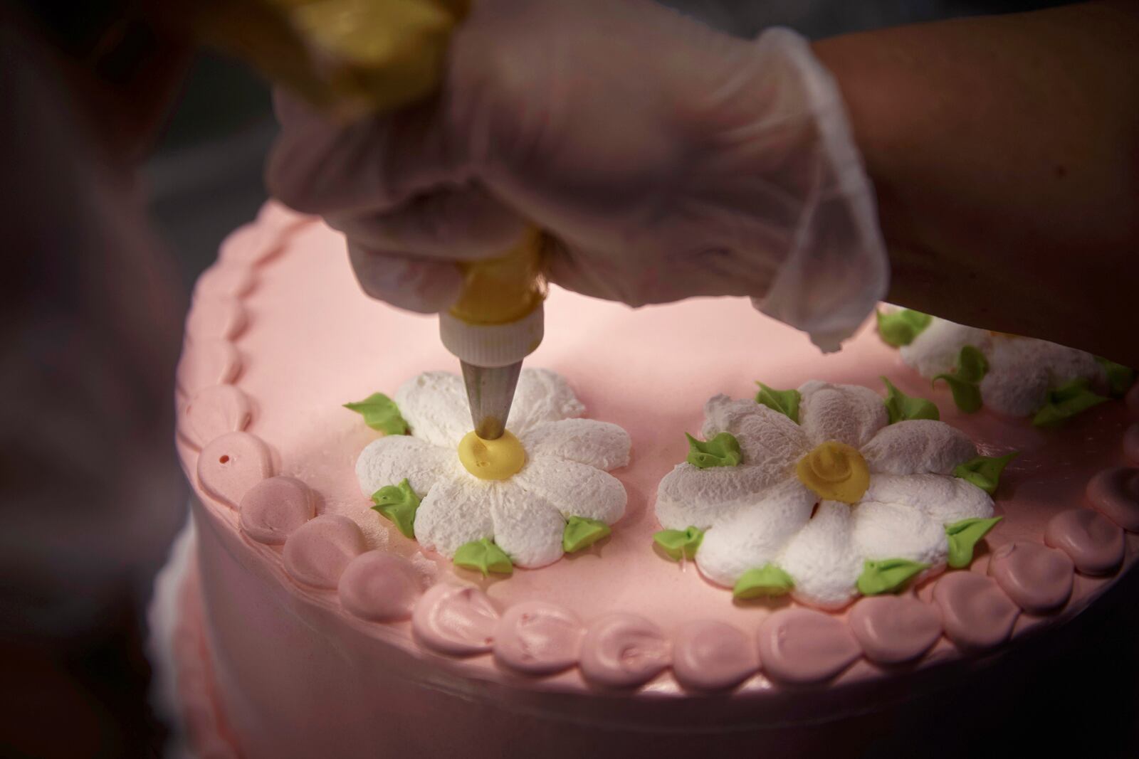An employee decorates a cake inside Walmart Supercenter on Wednesday, May 28, 2025, in North Bergen, N.J. (AP Photo/Andres Kudacki)