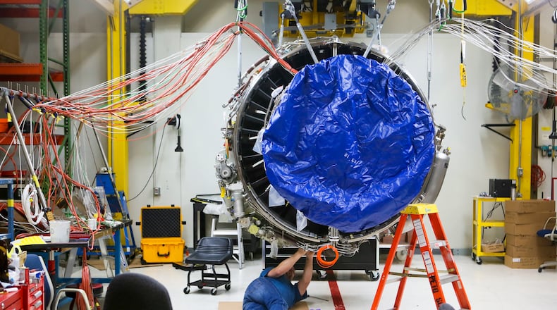 Engineers work on a LEAP commercial jet test engine at GE Aviation in Evendale, Friday, Dec. 19, 2014. The engine, made by CFM, a joint venture between GE and French  manufacturer Snecma, will be more fuel efficient and contain advanced materials, and will be transformative for the manufacturing industry because it will contain the first  mass-produced 3-D manufactured/additive component in a critical area. GREG LYNCH / STAFF