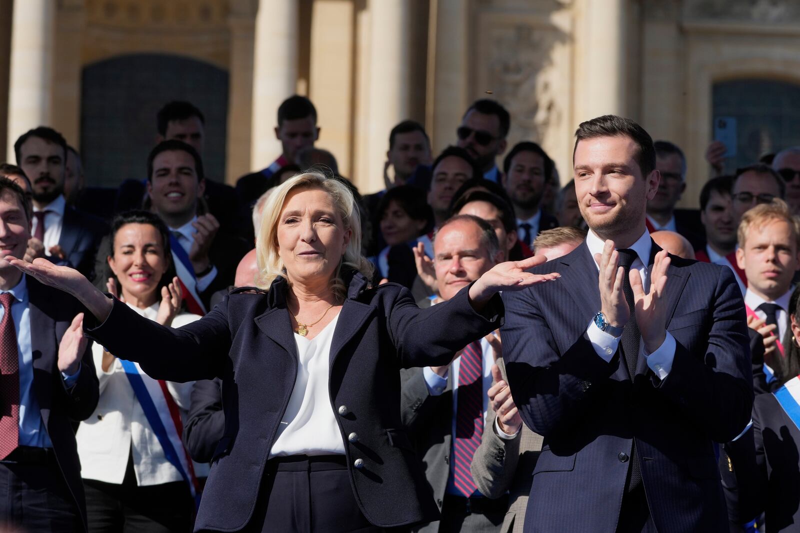 French far-right leader Marine Le Pen, left, reacts with Jordan Bardella during the French far-right party national rally near the parliament in Paris, Sunday, April 6, 2025. (AP Photo/Michel Euler)