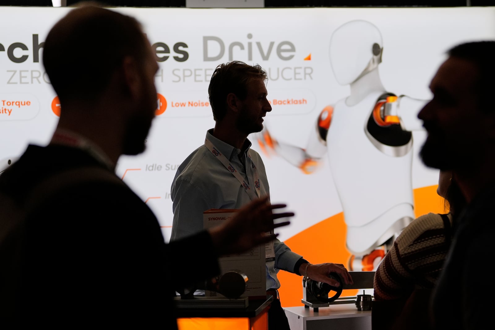 Casper van Eersel, center, a representative of IMSystems, a Netherlands-based company which makes robot components, talks with convention guests at the Robotics Summit & Expo, Wednesday, April 30, 2025, in Boston. (AP Photo/Charles Krupa)