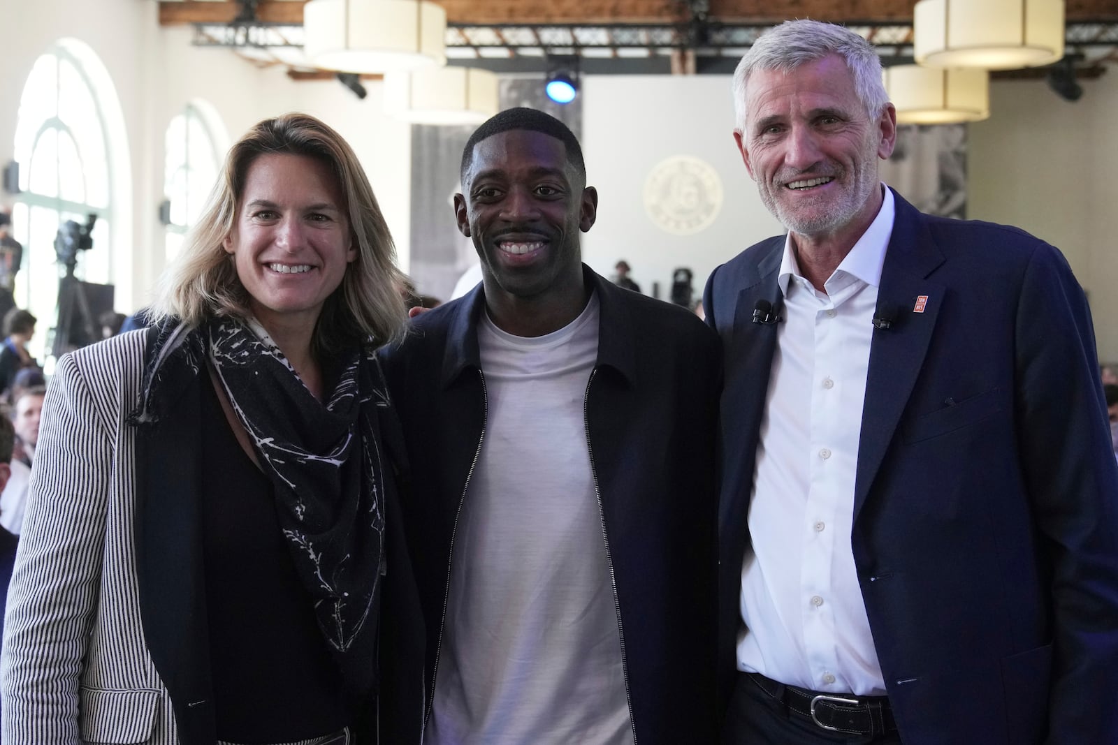 Tournament director Amelie Mauresmo, left, PSG soccer player Ousmane Dembele and French Tennis Federation president Gilles Moretton pose during the draw of French Open tennis tournament, Thursday, May 22, 2025 at the Roland Garros stadium in Paris. (AP Photo/Christophe Ena)