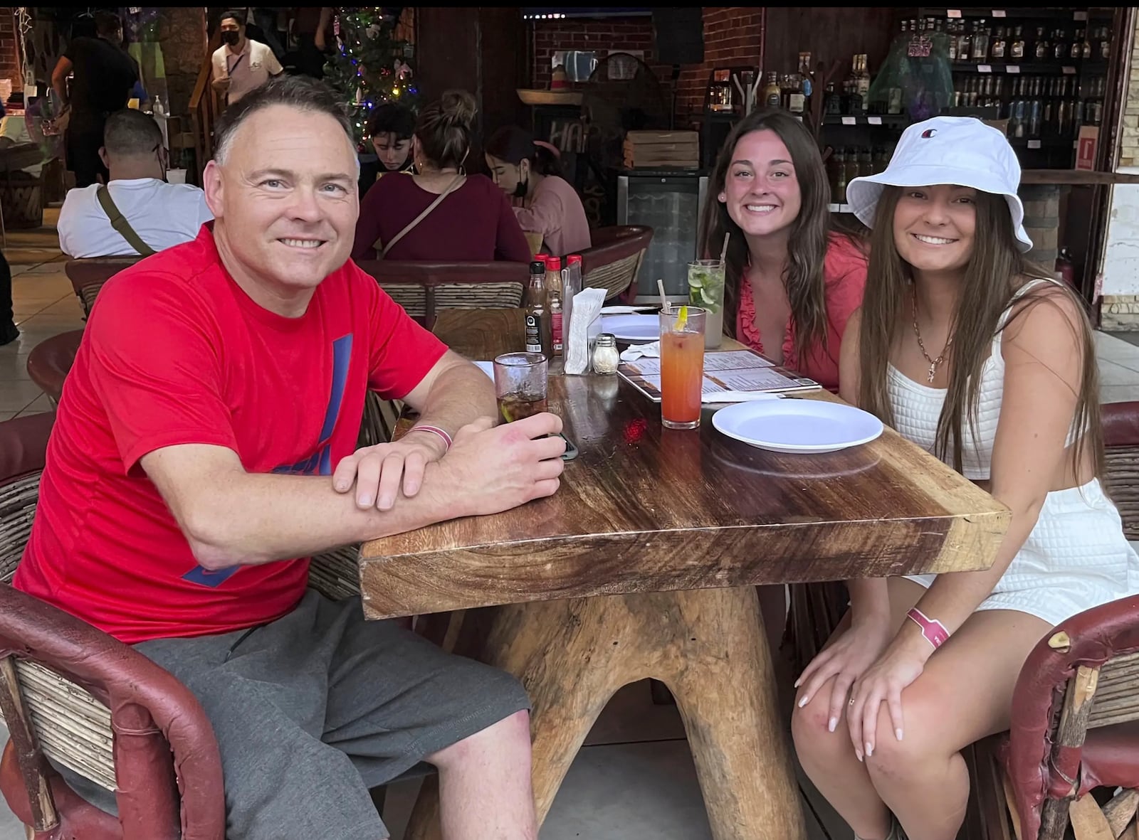 This Dec. 2021 photo provided by Jazzmin Kernodle shows father Jeff Kernodle, left, Xana, middle, and Jazzmin, in Puerto Vallarta, Mexico. (Courtesy of Jazzmin Kernodle via AP)