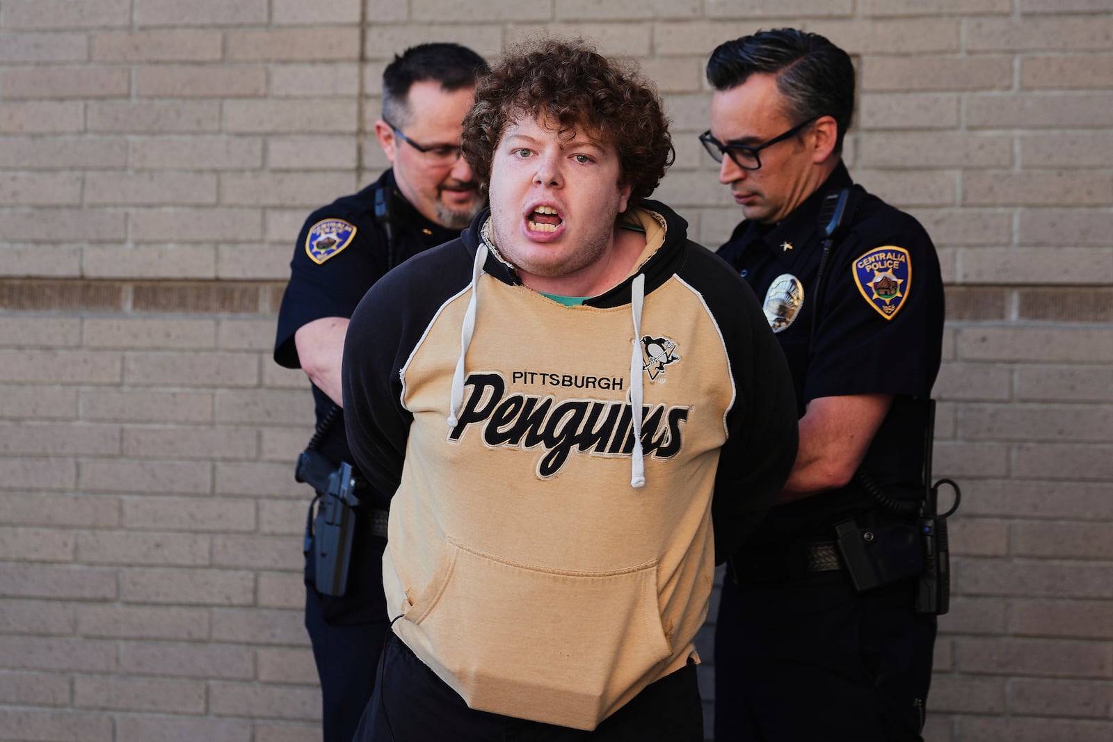 A protester is arrested by Centralia police officers at a town hall event with Rep. Marie Gluesenkamp Perez, D-Wash., at Centralia College, Tuesday, April 22, 2025, in Centralia, Wash. (AP Photo/Lindsey Wasson)
