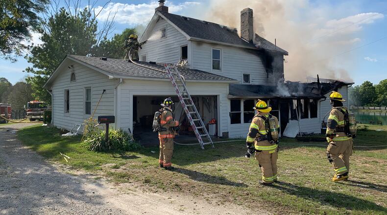 Firefighters work to put out a fire in Clearcreek Twp. Saturday that killed a woman. Contributed