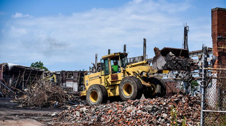 Crews from Vickers Demolition work to dismantle what is left a week after a massive warehouse fire on Laurel Avenue Wednesday, July 31 in Hamilton. The fire started just before 5 a.m. Thursday, July 25, 2019. NICK GRAHAM / STAFF