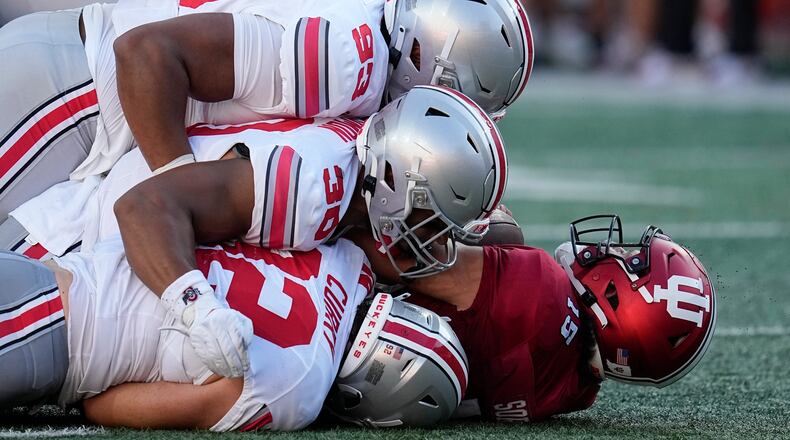 Indiana quarterback Brendan Sorsby (15) is sacked by Ohio State's Hero Kanu (93), Cody Simon (30) and Caden Curry (92) during the second half of an NCAA college football game, Saturday, Sept. 2, 2023, in Bloomington, Ind. (AP Photo/Darron Cummings)
