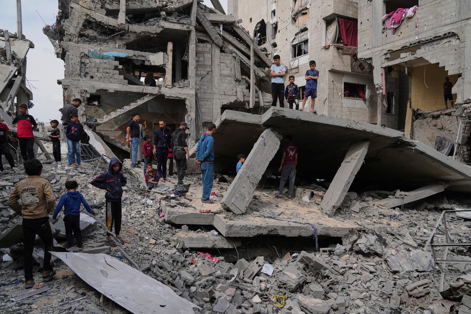 Palestinians inspect the rubble of the Al-Lahham family's home, destroyed by Israeli airstrikes in Khan Younis, Gaza Strip, on Thursday, May 15, 2025. (AP Photo/Abdel Kareem Hana)