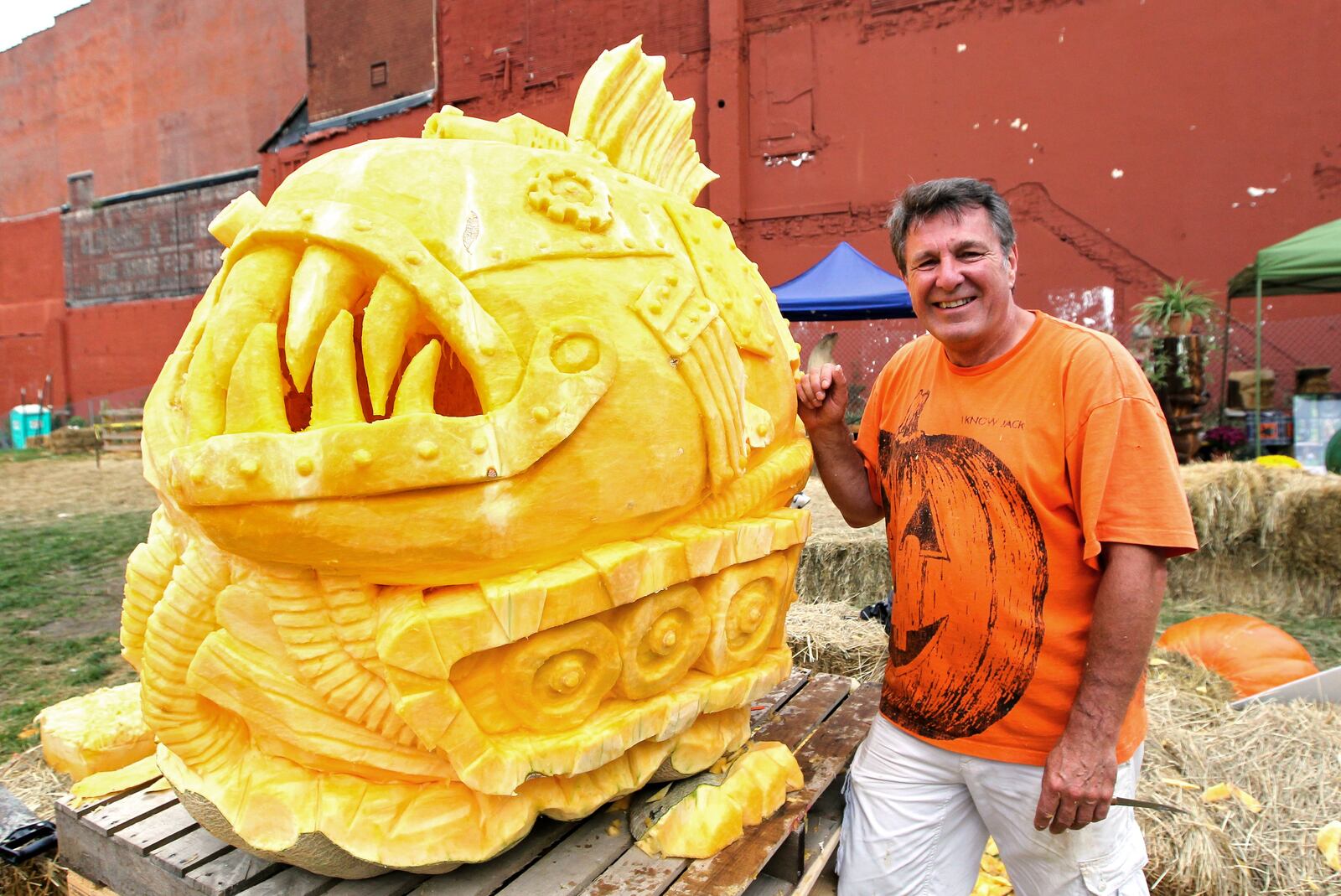 Russ Leno, of Everett, WA, stands next to his pumpkin carving at the Operation Pumpkin festival in downtown Hamilton Saturday, Oct. 5, 2013. NICK DAGGY / STAFF