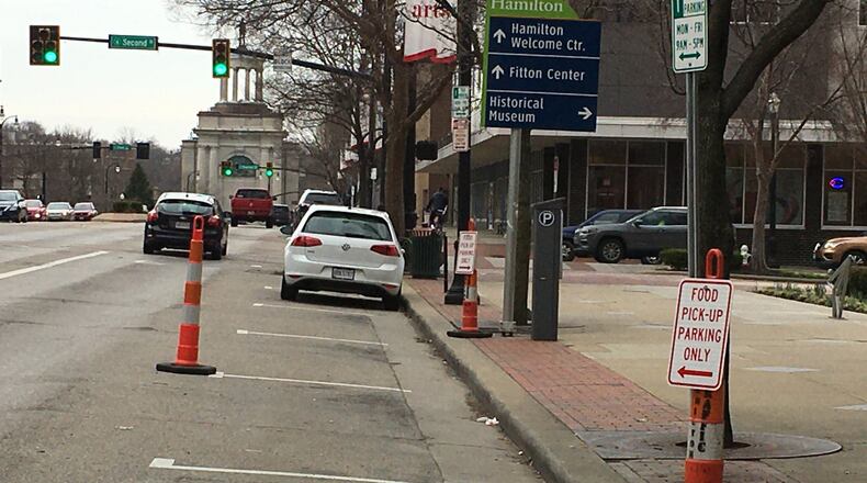 Space was reserved on High Street in Hamilton on Monday, March 16, 2020, for those parking to pick up carry-out food orders from restaurants. LAUREN PACK / STAFF