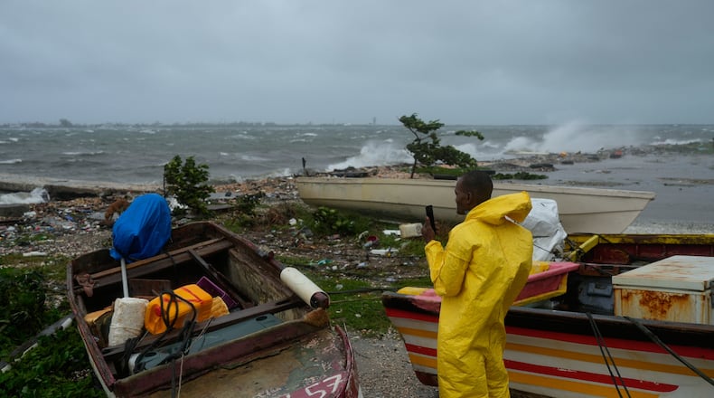 A man watches the coastline in Kingston, Jamaica, as Hurricane Melissa closes in, Tuesday, Oct. 28, 2025. (AP Photo/Matias Delacroix)