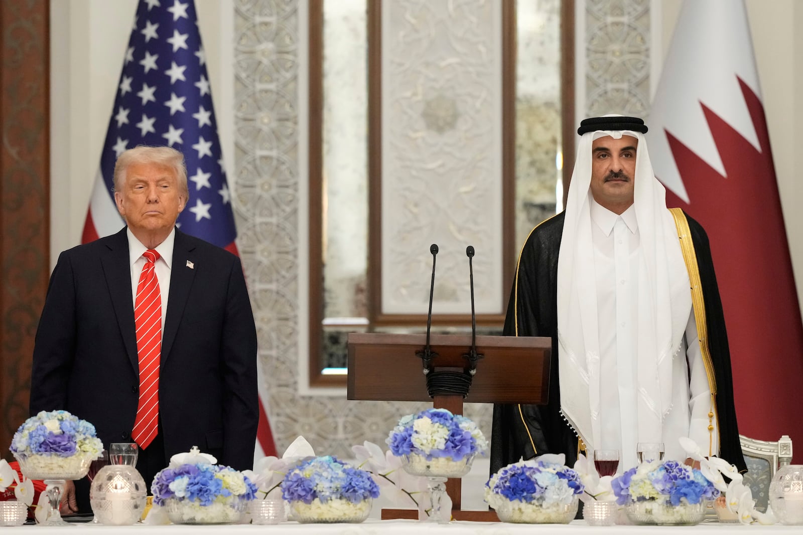 President Donald Trump and Qatar's Emir Sheikh Tamim bin Hamad Al Thani stand during the U.S. national anthem at a state dinner at Lusail Palace in Doha, Qatar, Wednesday, May 14, 2025. (AP Photo/Alex Brandon)