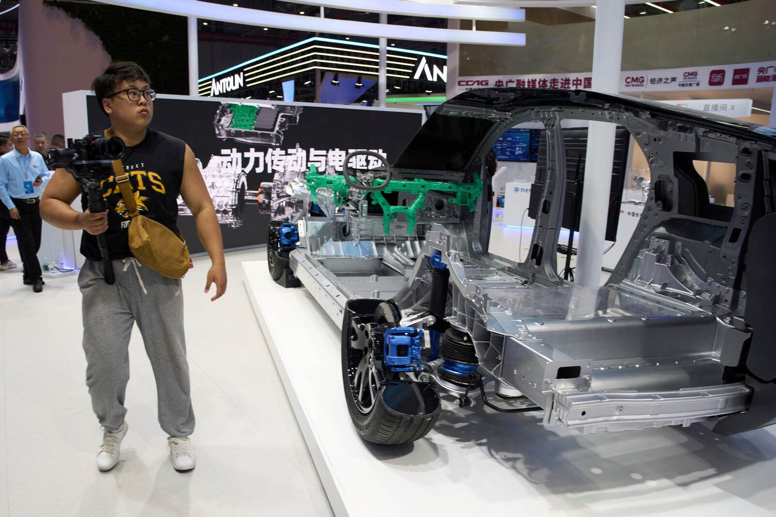 A man walks past a cut out showing the parts from Chinese auto parts manufacturer CCAG during the Shanghai auto show on Thursday, April 24, 2025. (AP Photo/Ng Han Guan)