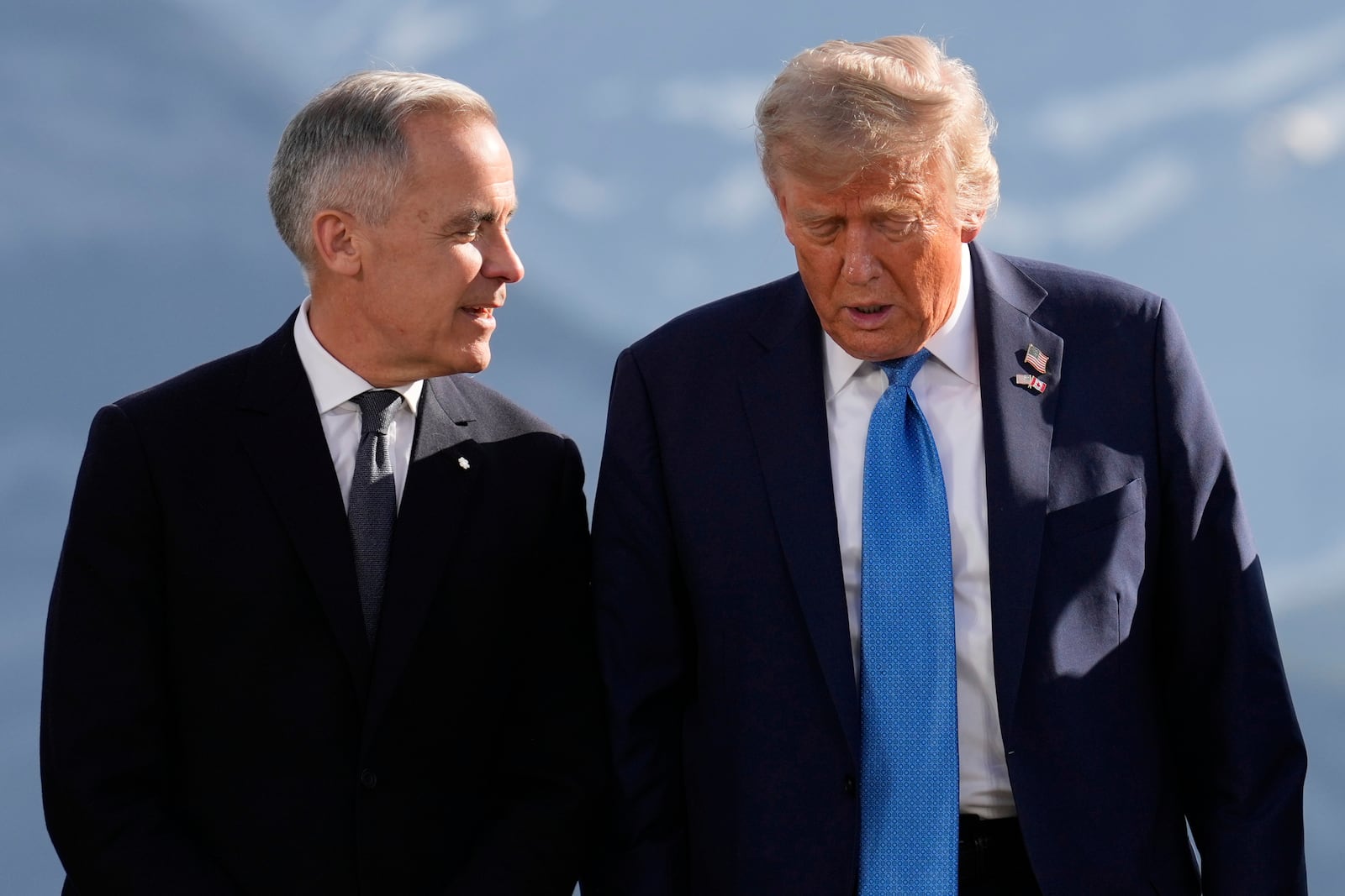 Canada's Prime Minister Mark Carney talks with President Donald Trump before a group photo at the G7 Summit, Monday, June 16, 2025, in Kananaskis, Canada. (AP Photo/Mark Schiefelbein)