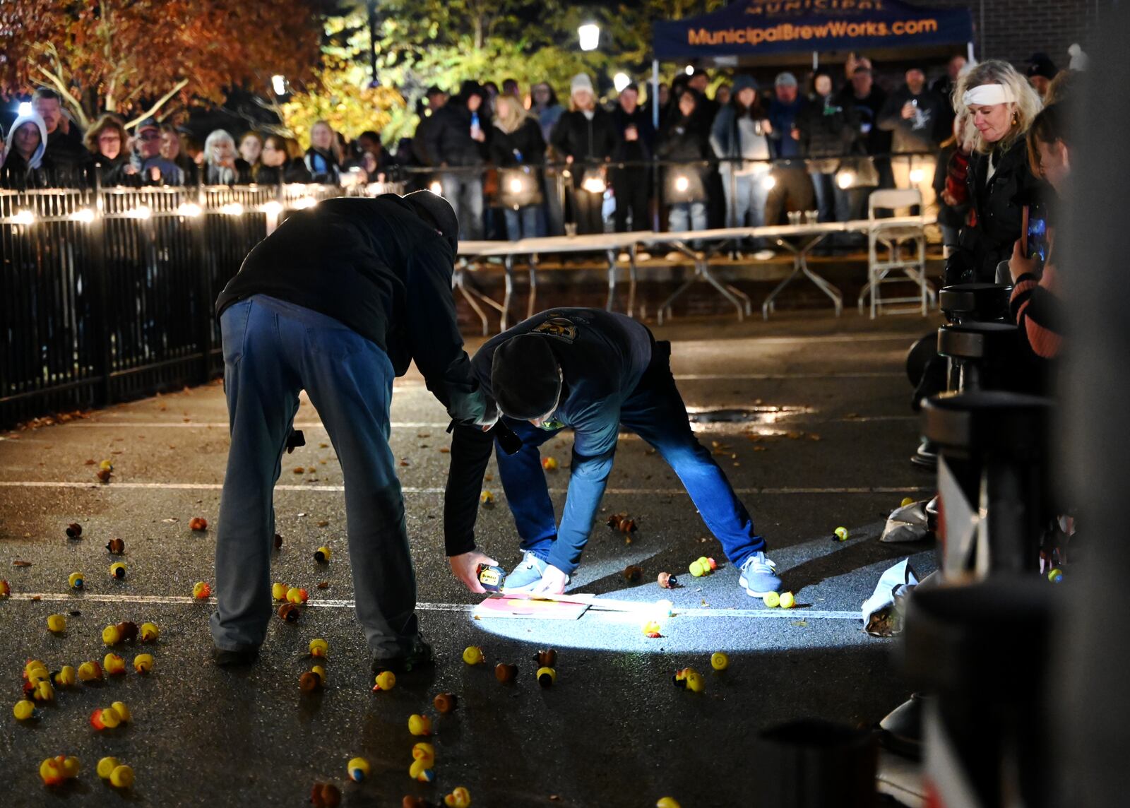The annual Hamilton Turkey Drop raised more than $3,000 in its second year for the Butler County Veterans Memorial Wall project. There were 470 ducks sold, selling more than initially intended, for this year's pre-Thanksgiving event that celebrates the famous 1978 "WKRP in Cincinnati" turkey drop episode. In its inaugural year, the Hamilton Turkey Drop raised $2,000 for the project to update the memorial wall at Veterans Park. The ducks were dropped from a Hamilton Fire Department ladder truck onto one of five targets. One person won $500 and four won $100. Pictured is Municipal Brew Works co-owner Jim Goodman measuring the proximity of a duck near one of the five targets. MICHAEL D. PITMAN/STAFF