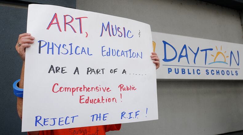 A crowd of people protest layoffs of teachers outside the Dayton Public Schools headquarters building on Ludlow Street Friday.