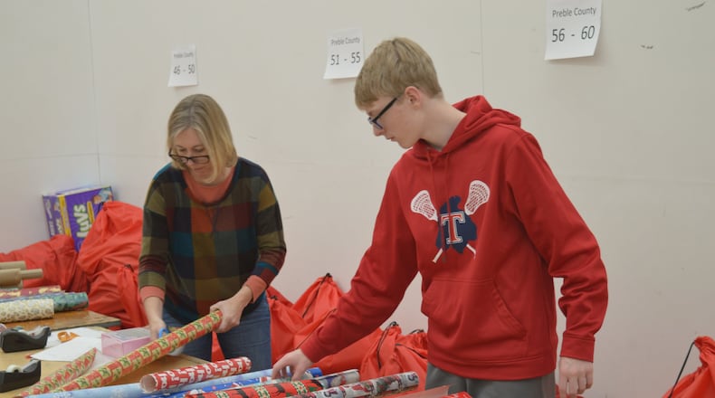 Gunnar Von Bergen, a Talawanda High School freshman, joined his mother, Erin, helping to wrap gifts for Miami s Holiday Project. Erin Von Bergen works at Miami and said while she was growing up, her mother was a CASA volunteer. CONTRIBUTED/BOB RATTERMAN