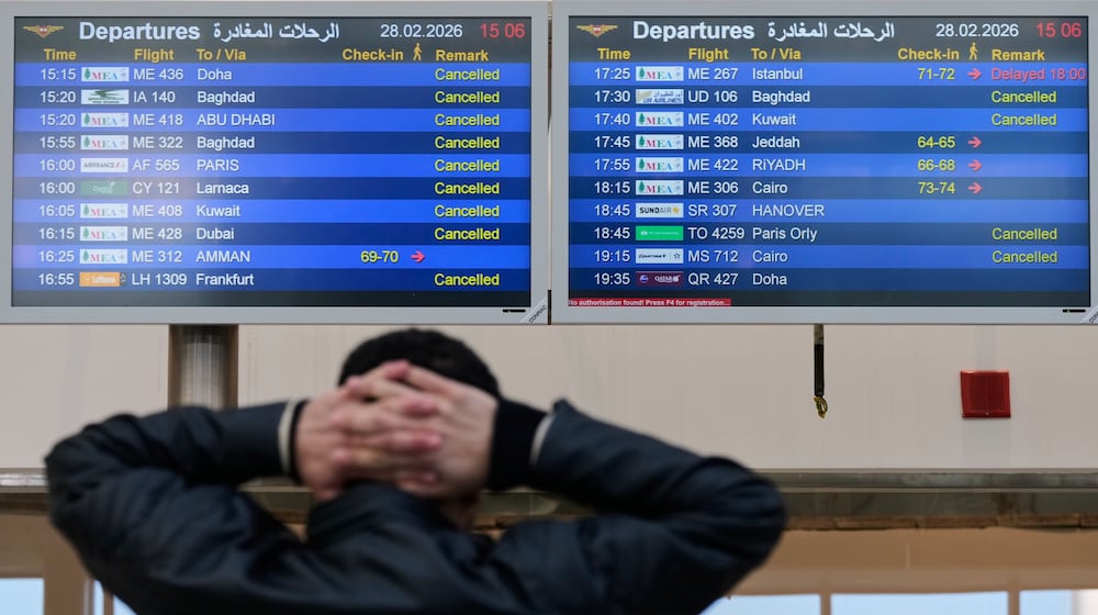 A traveler checks departure times as many flights are cancelled at Beirut Rafik Hariri International Airport in Beirut, Lebanon, Saturday, Feb. 28, 2026, as many airlines canceled flights due to the conflict involving the United States, Israel and Iran. (AP Photo/Hassan Ammar)
