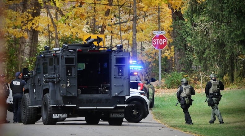 Dayton, police and swat team Montgomery county sheriffs around the house on Hacker Road after an officer was shot while serving a warrant Thursday afternoon. MARSHALL GORBY \STAFF
