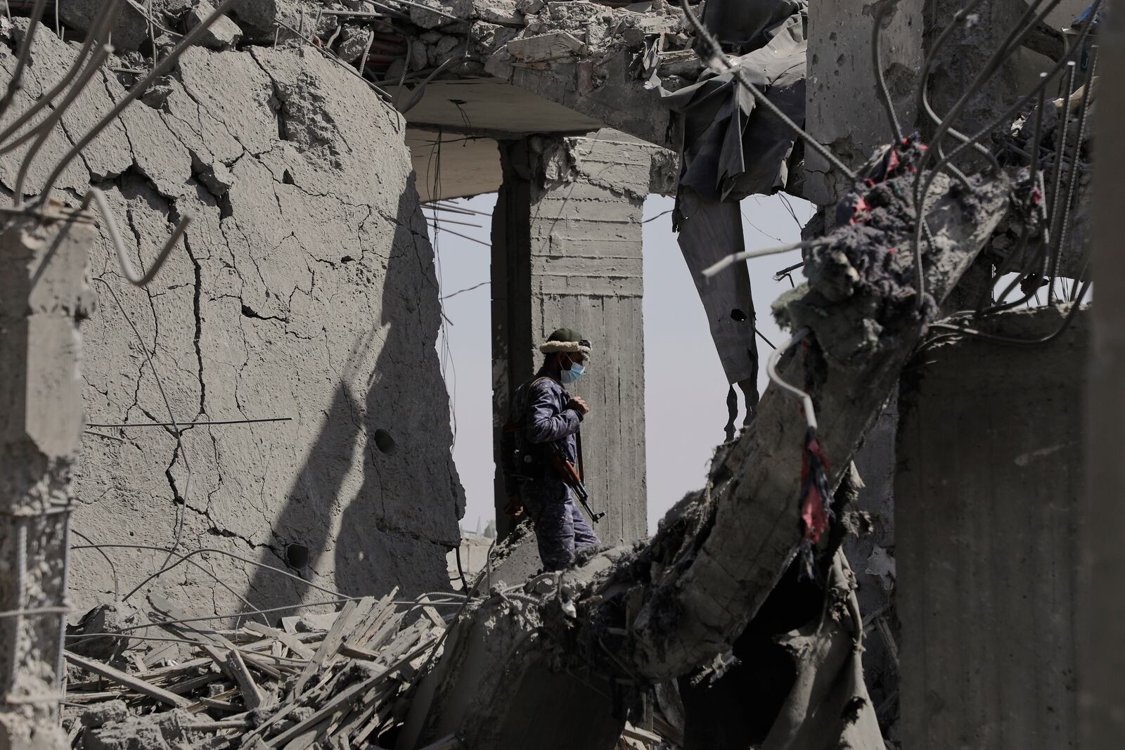 A Houthi security officer inspects the debris of a destroyed building reportedly hit by U.S. airstrikes in Sanaa, Yemen, Monday, April 7, 2025. (AP Photo)