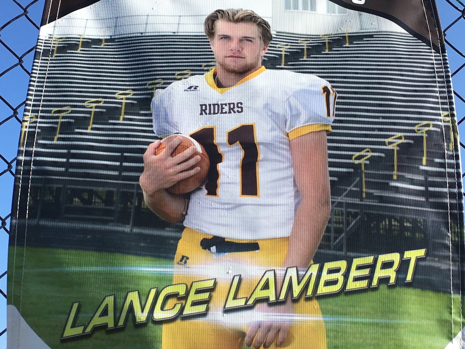 West Jefferson High School senior quarterback Lance Lambert is pictured on a banner hanging near the school’s tennis courts this week in Madison County. RICK CASSANO/STAFF