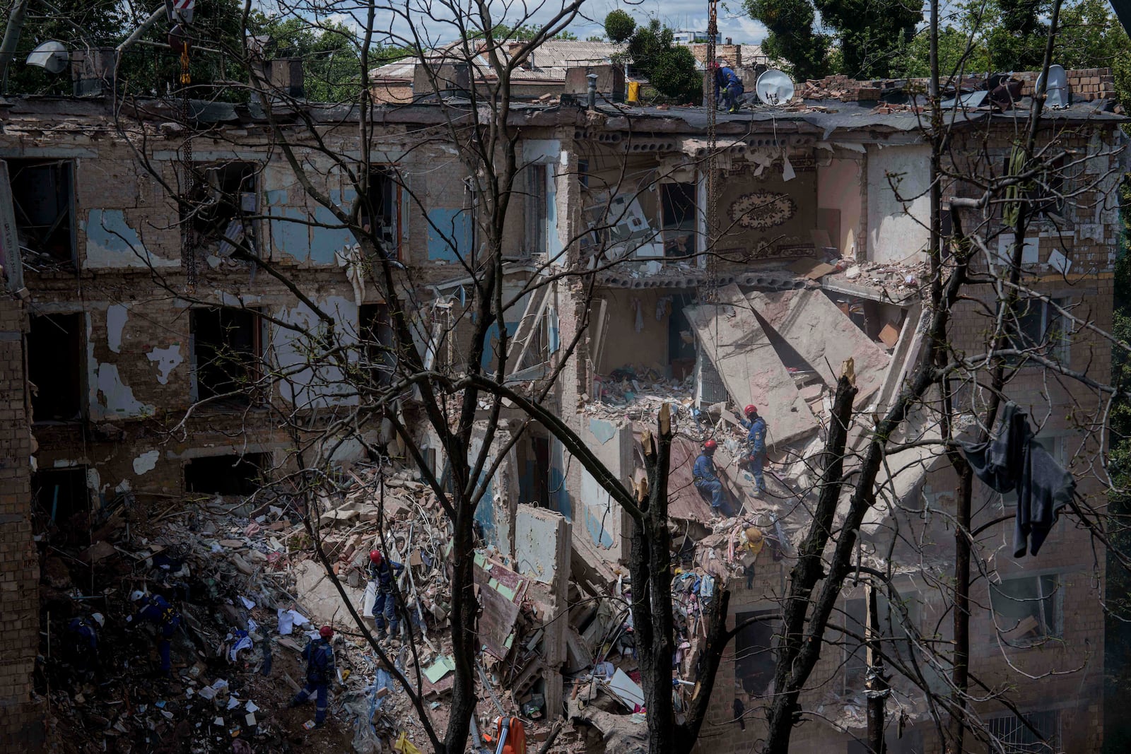 Rescue workers clear the rubble of a residential house destroyed by a Russian strike in Kyiv, Ukraine, on Monday, June 23, 2025. (AP Photo/Evgeniy Maloletka)