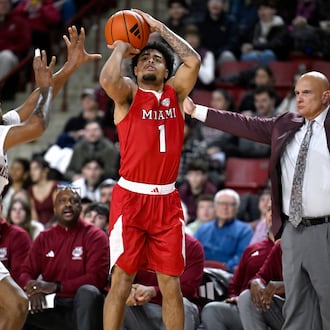 Miami Ohio guard Trey Perry shoots as UMass guard K'Jei Parker, left, defends and UMass head coach Frank Martin looks on, in the first half of an NCAA college basketball game, Tuesday, Feb. 17, 2026, in Amherst, Mass. (AP Photo/Jessica Hill)