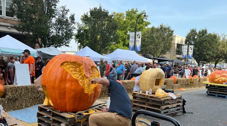 Visitors check out vendor booths, food trucks, and pumpkins of all shapes and sizes on High Street during Operation Pumpkin Saturday, Oct. 12, 2024 in downtown Hamilton. AMY BURZYNSKI/STAFF