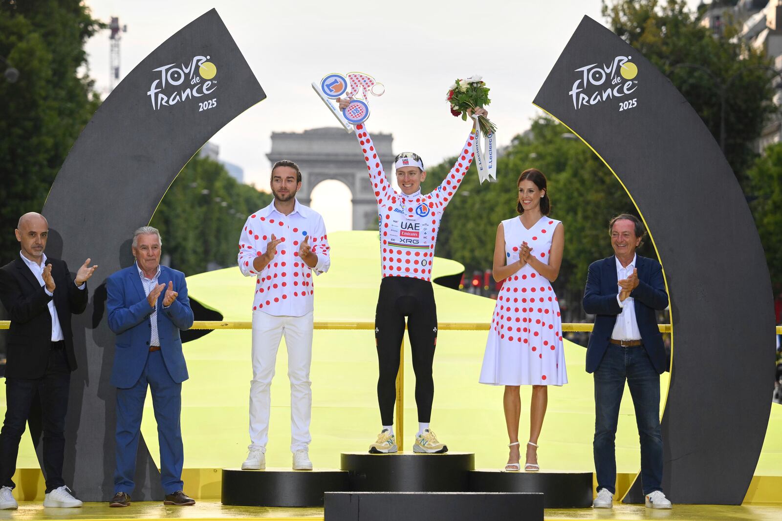 Slovenia's Tadej Pogacar, holds the award for the best climber as he celebrates during the presentation ceremony for the Tour de France on the Champs-Elysees in Paris, France, Sunday, July 27, 2025. (Bernard Papon, Pool Photo via AP)