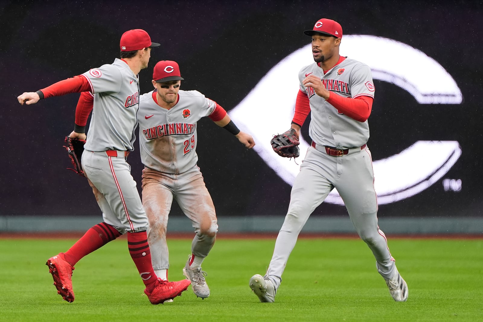 Cincinnati Reds outfielders Austin Hays, left, TJ Friedl (29) and Will Benson celebrate after their baseball game against the Kansas City Royals, Monday, May 26, 2025, in Kansas City, Mo. (AP Photo/Charlie Riedel)