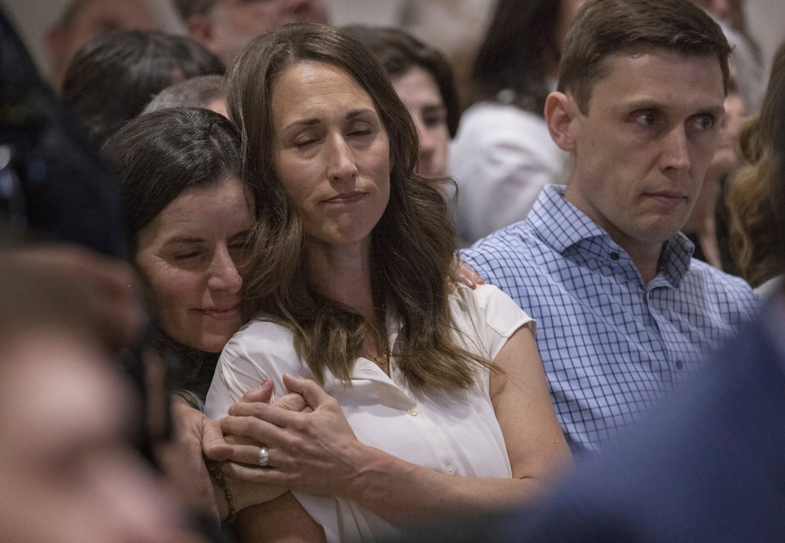 Jessica Brown, left, comforts Rivka Wilcoxson after Wilcoxson spoke about her family's loss during Chase Daniel Jones' sentencing on Friday, April 25, 2025, at the Maleng Regional Justice Center in Kent, Wash. Rivka's husband, Chace, is at right. (Ellen M. Banner/The Seattle Times via AP)