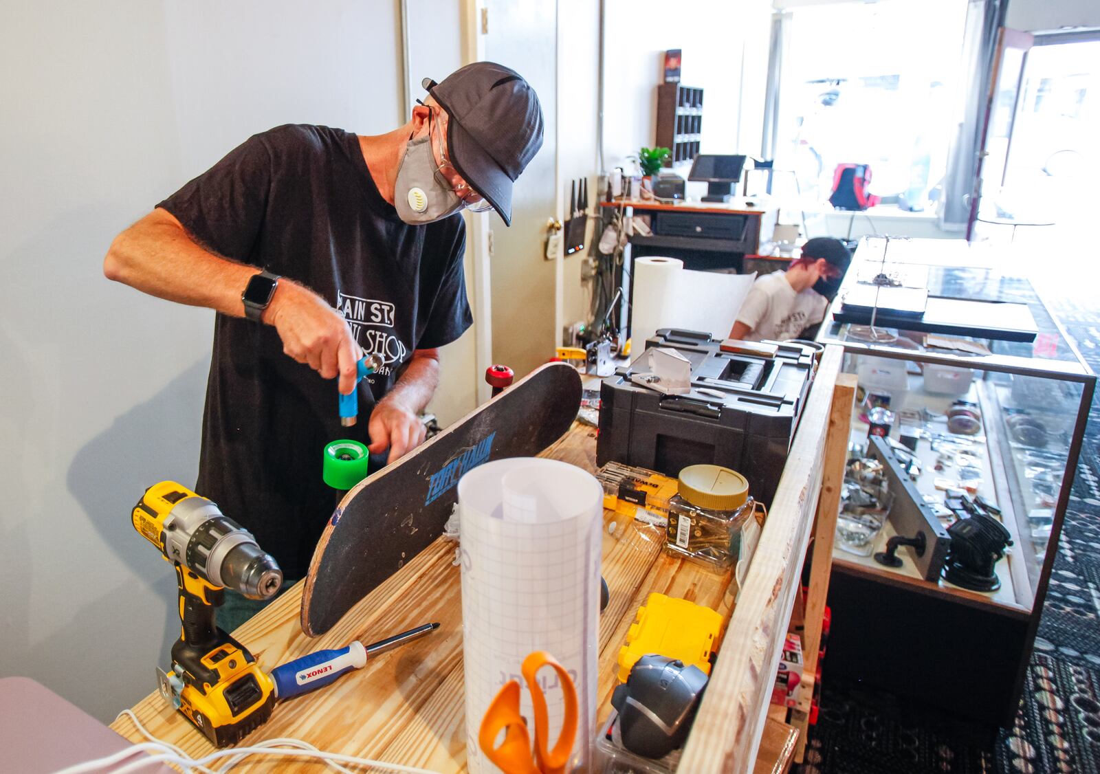 John Simmons, owner of Main Street Throw Shop, works on a skateboard on opening day at the business Friday, August 14, 2020 in Hamilton. The shop offers a wide variety of disc golf discs and bags, skateboards and accessories and has an area to test discs before you buy. NICK GRAHAM / STAFF
