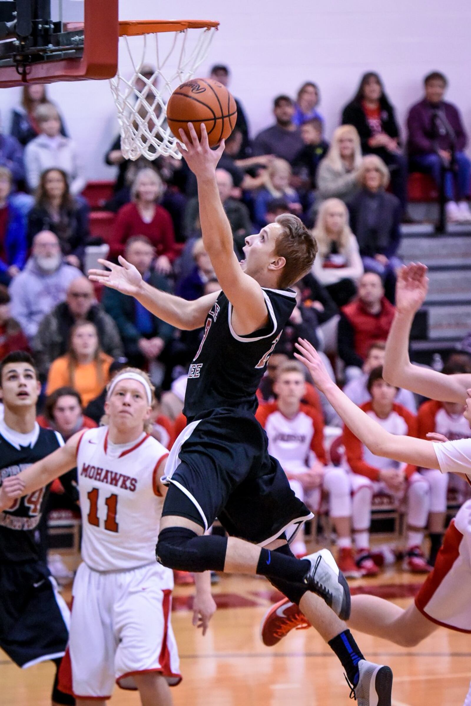 Preble Shawnee’s Joey Bates goes in for a layup as Madison’s Donovan King (11) watches on Friday night at Madison. NICK GRAHAM/STAFF