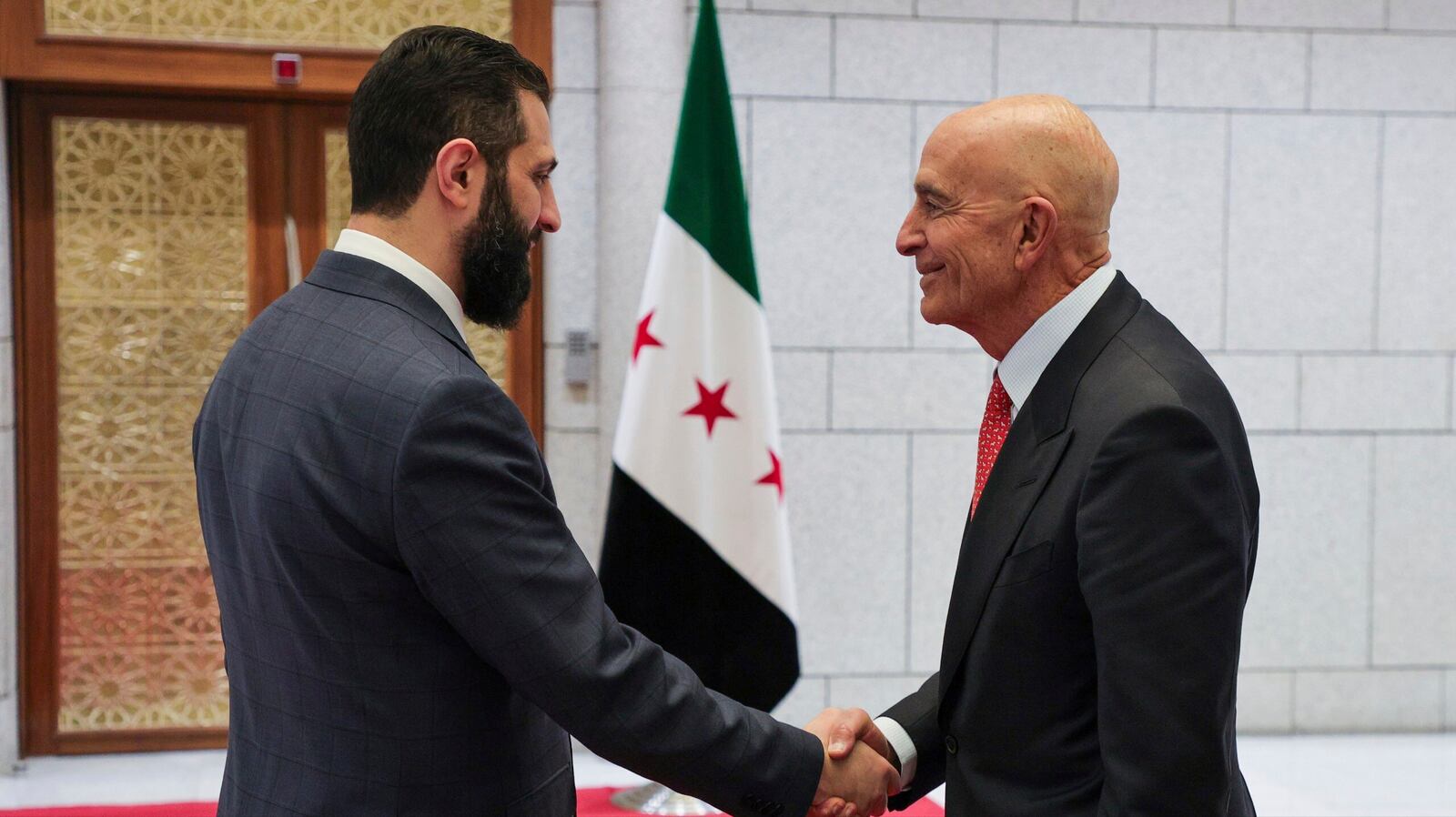 In this photo released by the Syrian official news agency SANA, Syria's interim President Ahmad al-Sharaa, left, shakes hands with U.S. Ambassador to Turkey and Special Envoy to Syria Tom Barrack, in Damascus, Syria, May 29, 2025. (SANA via AP)