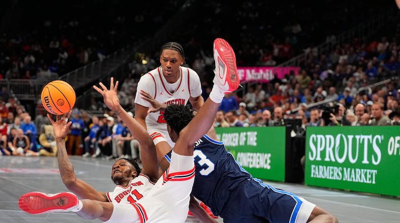 Houston's Joseph Tugler (11) passes as BYU's AJ Dybantsa (3) defends during the first half of an NCAA college basketball game in the quarterfinal round of the Big 12 Conference tournament Thursday, March 12, 2026, in Kansas City, Mo. (AP Photo/Charlie Riedel)