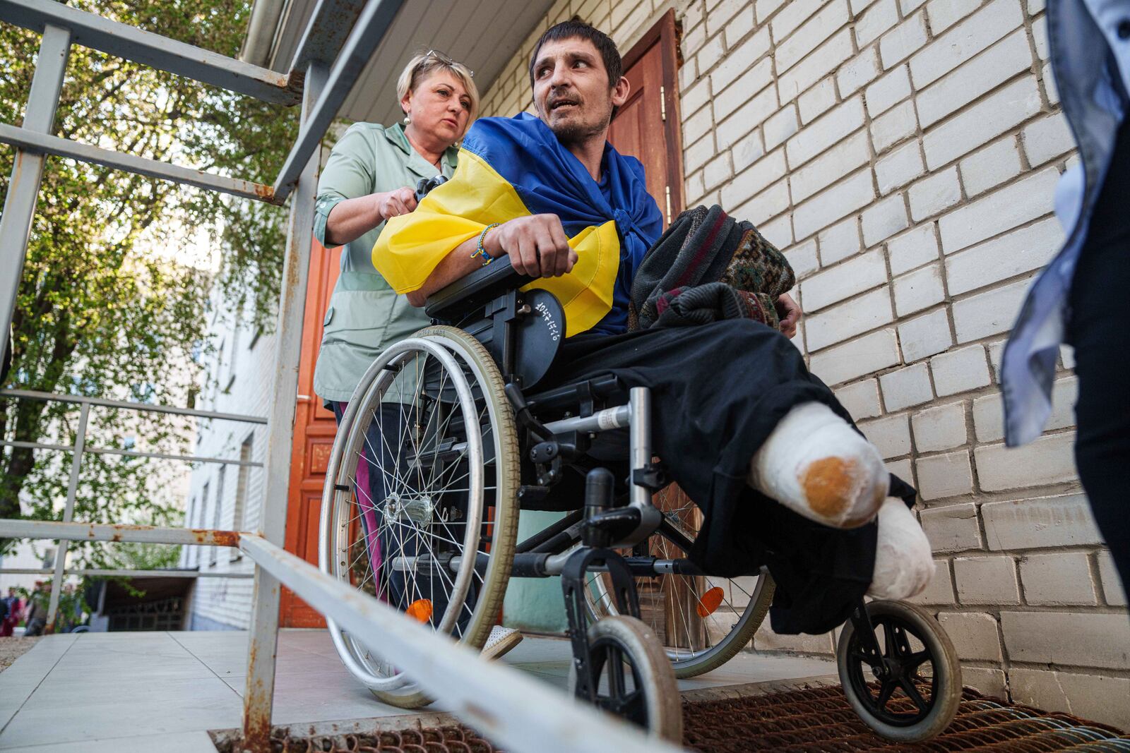 A medical worker uses a wheelchair to move an injured Ukrainian soldier from an ambulance after returning from captivity in a POW exchange in Ukraine, on Saturday, April. 19, 2025. (AP Photo/Evgeniy Maloletka)