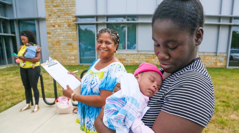 Tiara Thomas holds her baby So-Nae Turner as Natalie Jones, a certified community health worker from Butler County Moms and Babies First, looks on. Butler County’s new “BabyLink” service will provide critical information to mothers to help ensure they deliver a healthy baby. GREG LYNCH / STAFF
