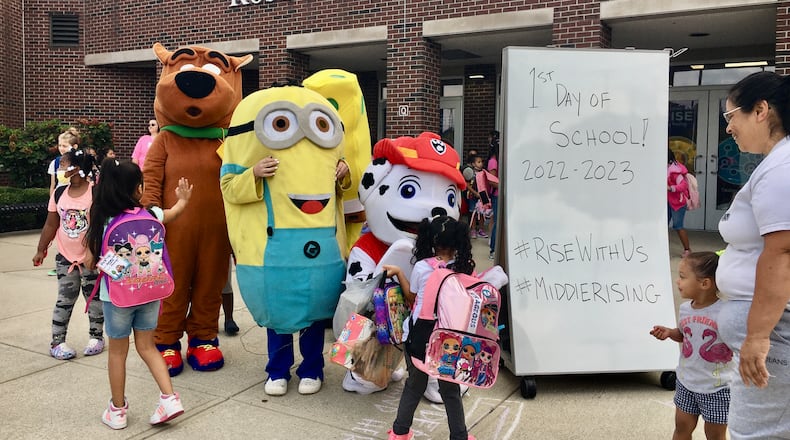 It was a full-scale opening day Monday for all 6,300 students in Middletown Schools but those youngsters coming to Rosa Parks Elementary were also greeted by costumed movie characters, a bubble machine and school staffers in superhero capes. Middletown's 10 public schools officially began full-attendance classes Monday for the new school year. (Photo By Michael D. Clark\Journal-News)
