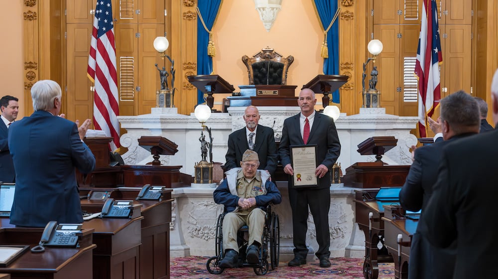 Jim Erisman, a 99-year-old World War II veteran from Farmersville, was honored by the Ohio Senate on Nov. 19, 2025. He's joined on the Senate floor by his son, Jim Erisman, Jr., and Sen. Steve Huffman, R-Tipp City. Courtesy Matt Shadle, Ohio Senate.